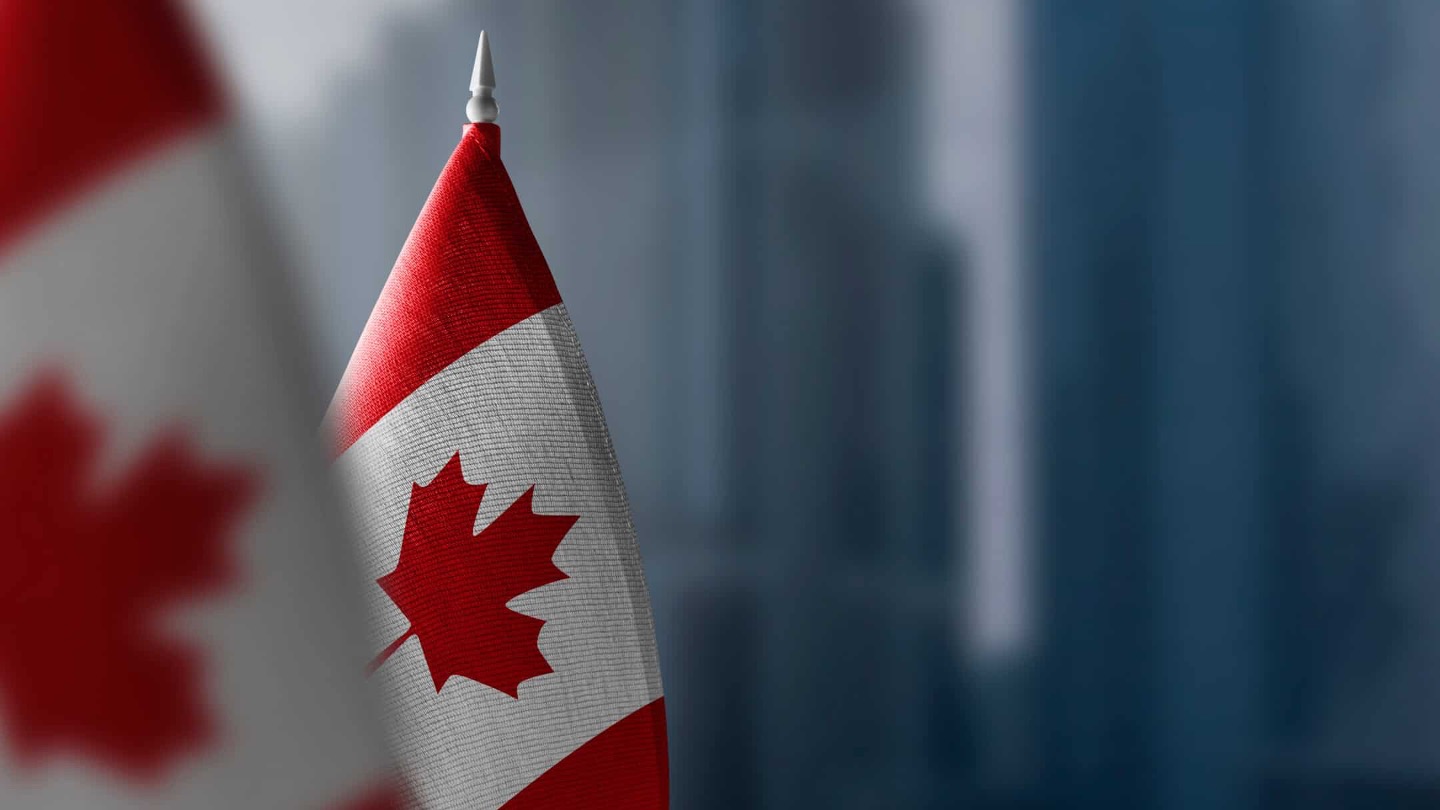 Two Canadian flags, one in the foreground and one in the background.